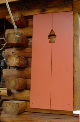 log cabin with pine tree shutters