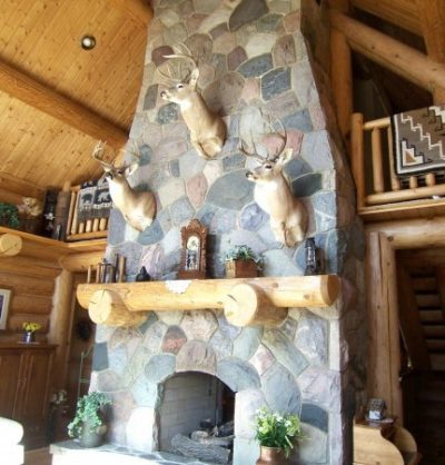 3 deer heads over stone fireplace